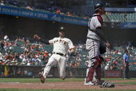 San Francisco Giants' Curt Casali slides into home plate to score near Arizona Diamondbacks catcher Carson Kelly during the seventh inning of a baseball game Thursday, June 17, 2021, in San Francisco. Casali scored after the Giants' Steven Duggar doubled to deep right field. (AP Photo/Eric Risberg)