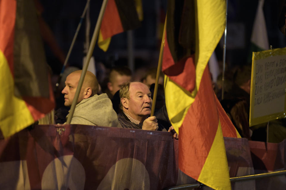 Demonstrators with German flags attend a protest against the visit of German Chancellor Angela Merkel at the East German city Chemnitz on Friday, Nov. 16, 2018. (AP Photo/Jens Meyer)