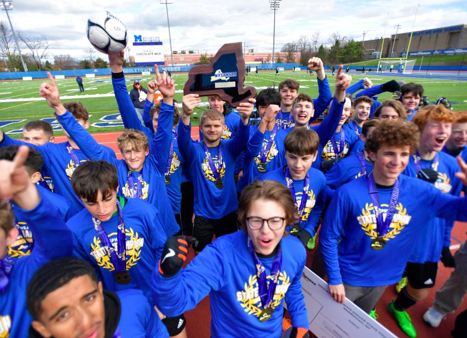 Fillmore players raise the championship plaque after winning the Class D final at the NYSPHSAA Boys Soccer Championships in Middletown, N.Y., Sunday, Nov. 13, 2022. Fillmore won the Class D title with a 2-0 win over Chazy-VII.