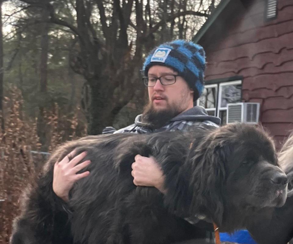 Gabe Jackson carries his dog, Keats, after the family found him on Dec. 30.