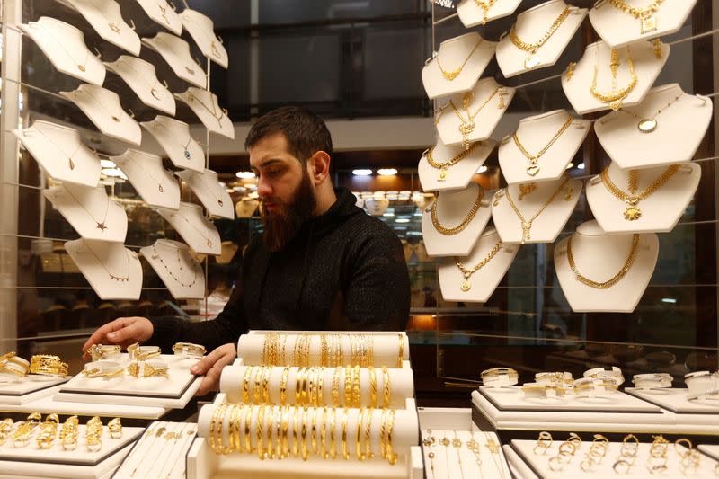 A salesman arranges gold bracelets inside a jewellery shop in Beirut