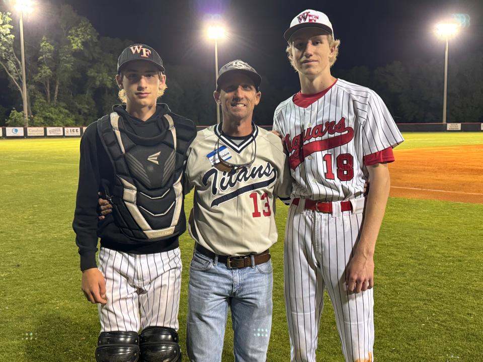 Former Woodham baseball player, John Robbins (middle), stands with his two sons, Brett (left) and Dax, who are players on the West Florida baseball team. The Jaguars play at the Titans' old field, and honored both teams on Friday, March 12, 2024.