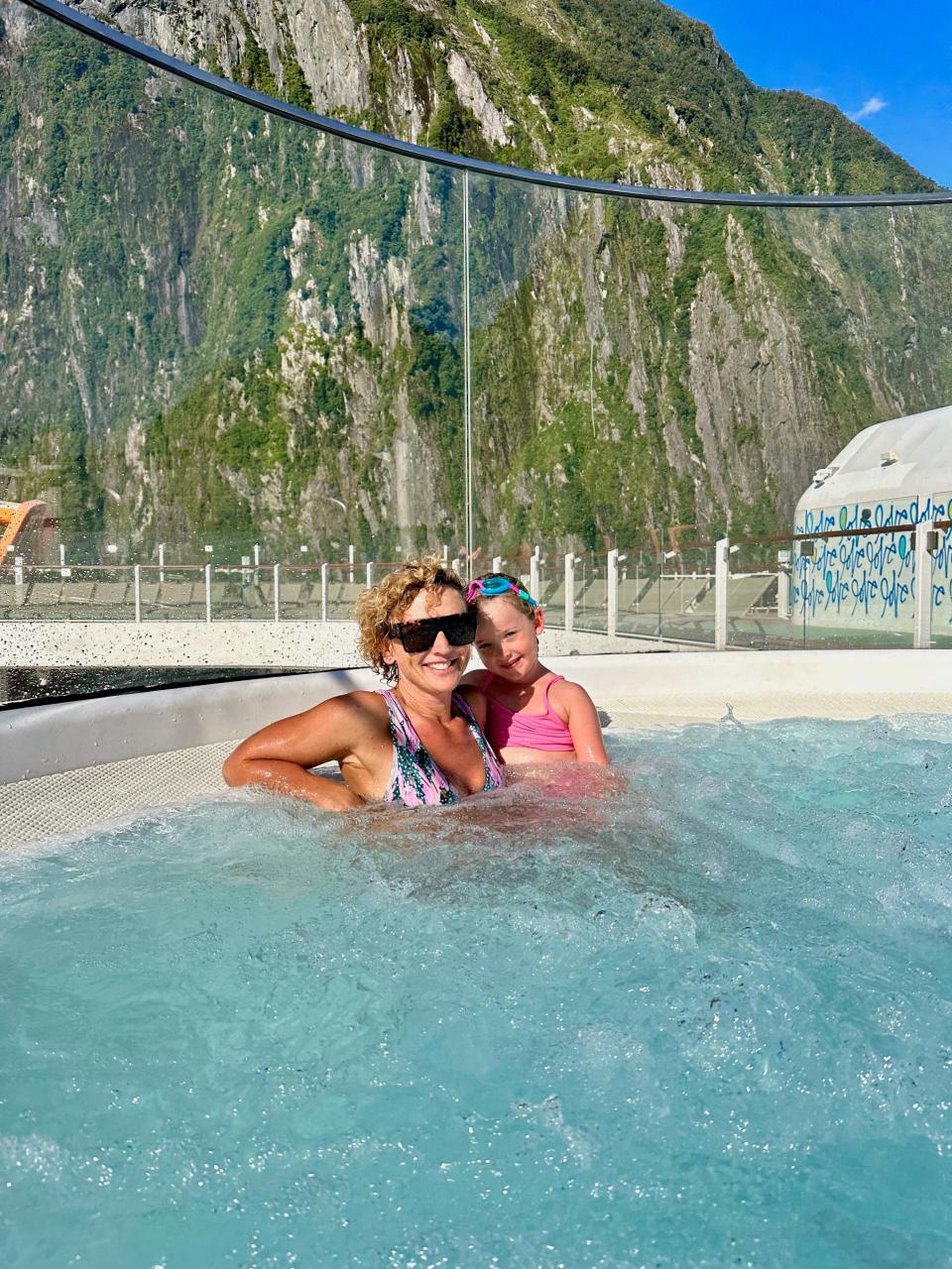 Mother and daughter in hot tub with mountain in the background