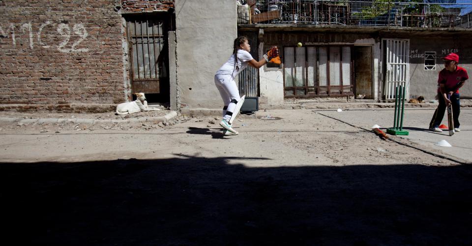 Milagros Mendez, left, catches a ball during a Caacupe cricket team training session at the Villa 21-24 slum in Buenos Aires, Argentina, Saturday, March 22, 2014. The International Cricket Council has recognized the team, formed from the children of the Villa 21-24 shantytown, honoring them as a global example for expanding the sport, which in certain countries, like India, is widely played, but in many parts of the world restricted to elite sectors of society. Introducing cricket in the slum began in 2009 as an idea to transform the game into a social integration mechanism, before that it rarely breached the gates of the country's upscale private schools. (AP Photo/Natacha Pisarenko)