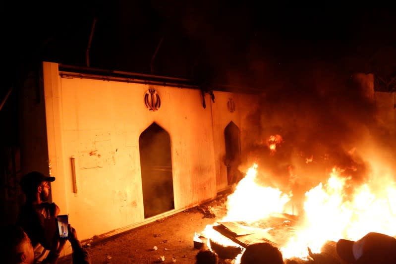 Demonstrators set fire in front of the Iranian consulate, as they gather during ongoing anti-government protests in Najaf