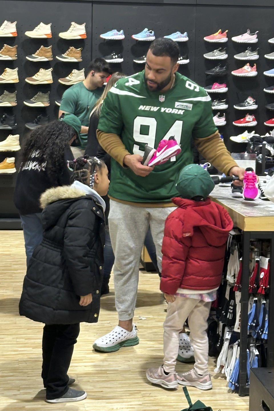 New York Jets defensive lineman Solomon Thomas helps young students from Brooklyn Community Services Jets' Academy during a holiday shopping spree hosted by the team at Dick's Sporting Goods in East Hanover, N.J., on Tuesday, Dec. 12, 2023. (AP Photo/Dennis Waszak Jr.)