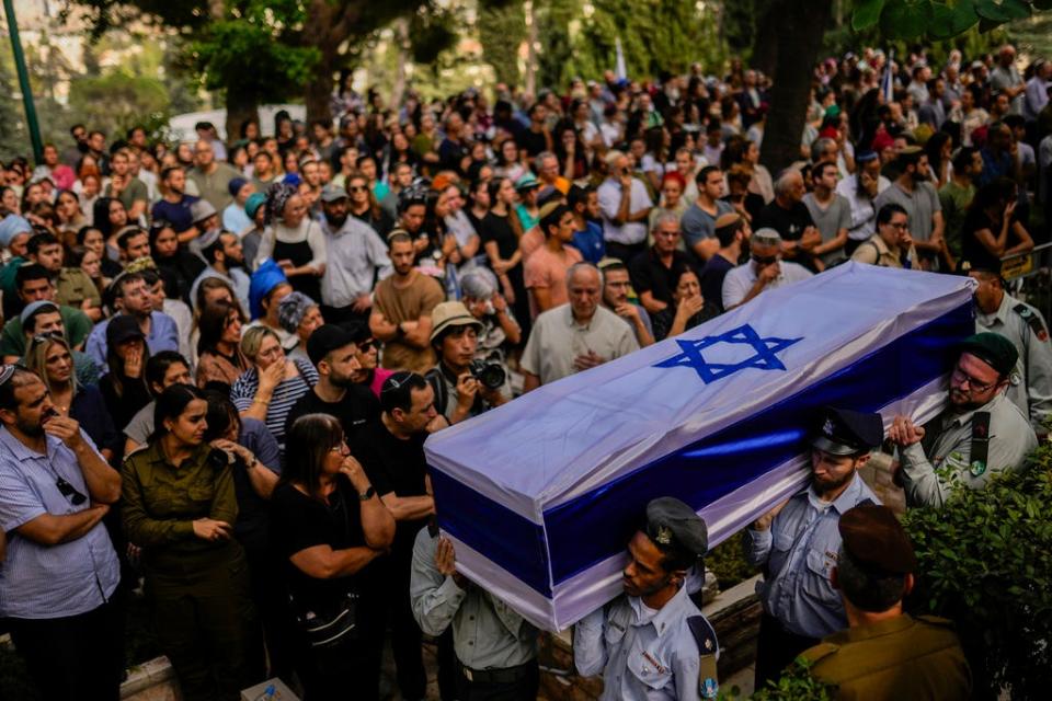 FILE - Israeli soldiers carry the flag-covered coffin of Shilo Rauchberger at the Mount Herzl cemetery in Jerusalem, Thursday, Oct. 12, 2023. Rabbis worked around the clock at Shura military base in Israel to identify and count the dead civilians and soldiers gunned down in the Hamas attack.