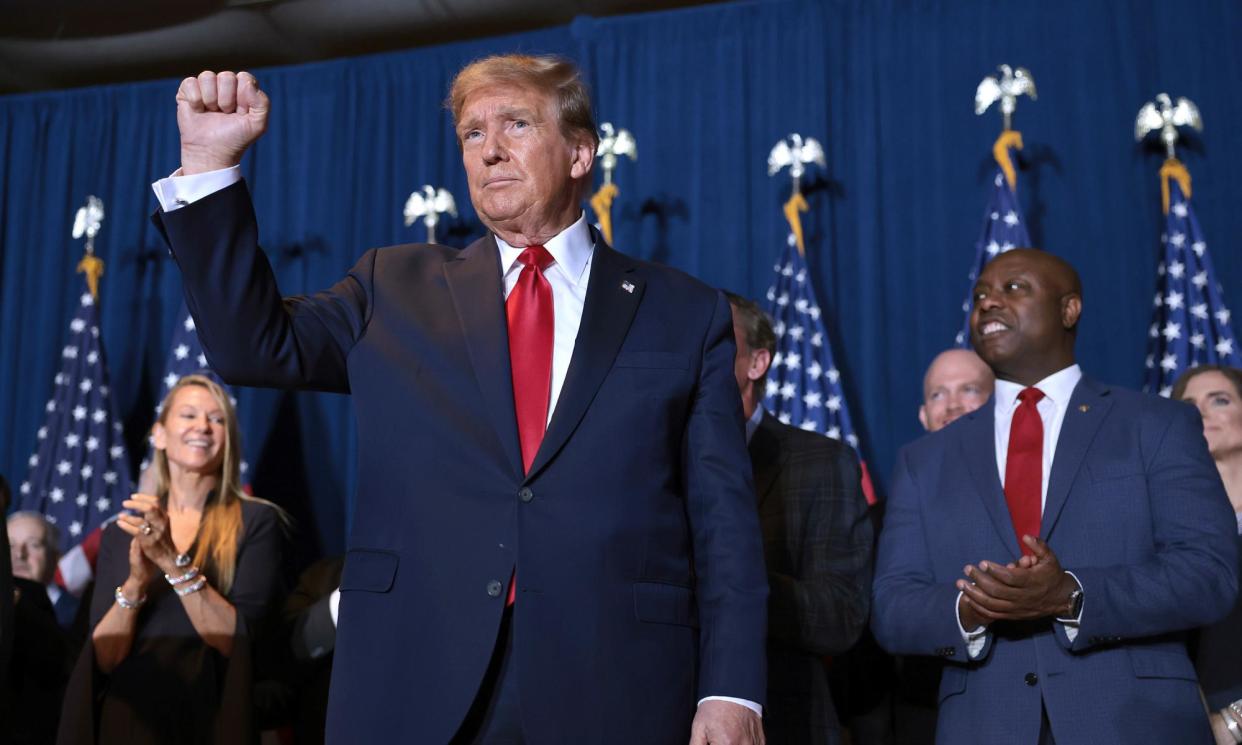 <span>Donald Trump celebrates his primary victory in Columbia, as Tim Scott looks on.</span><span>Photograph: Win McNamee/Getty Images</span>