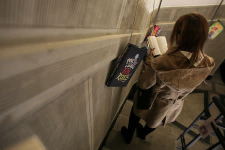 A woman reads a book on the stairs during the Night of Open Books event, inside the Arch of Triumph in Bucharest, Romania, April 23, 2019. Inquam Photos/Octav Ganea via REUTERS