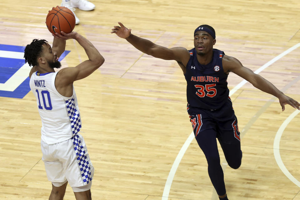 Kentucky's Davion Mintz takes a 3-point shot over Auburn's Devan Cambridge (35) late in the second half of an NCAA college basketball game in Lexington, Ky., Saturday, Feb. 13, 2021. Kentucky won 82-80. (AP Photo/James Crisp)