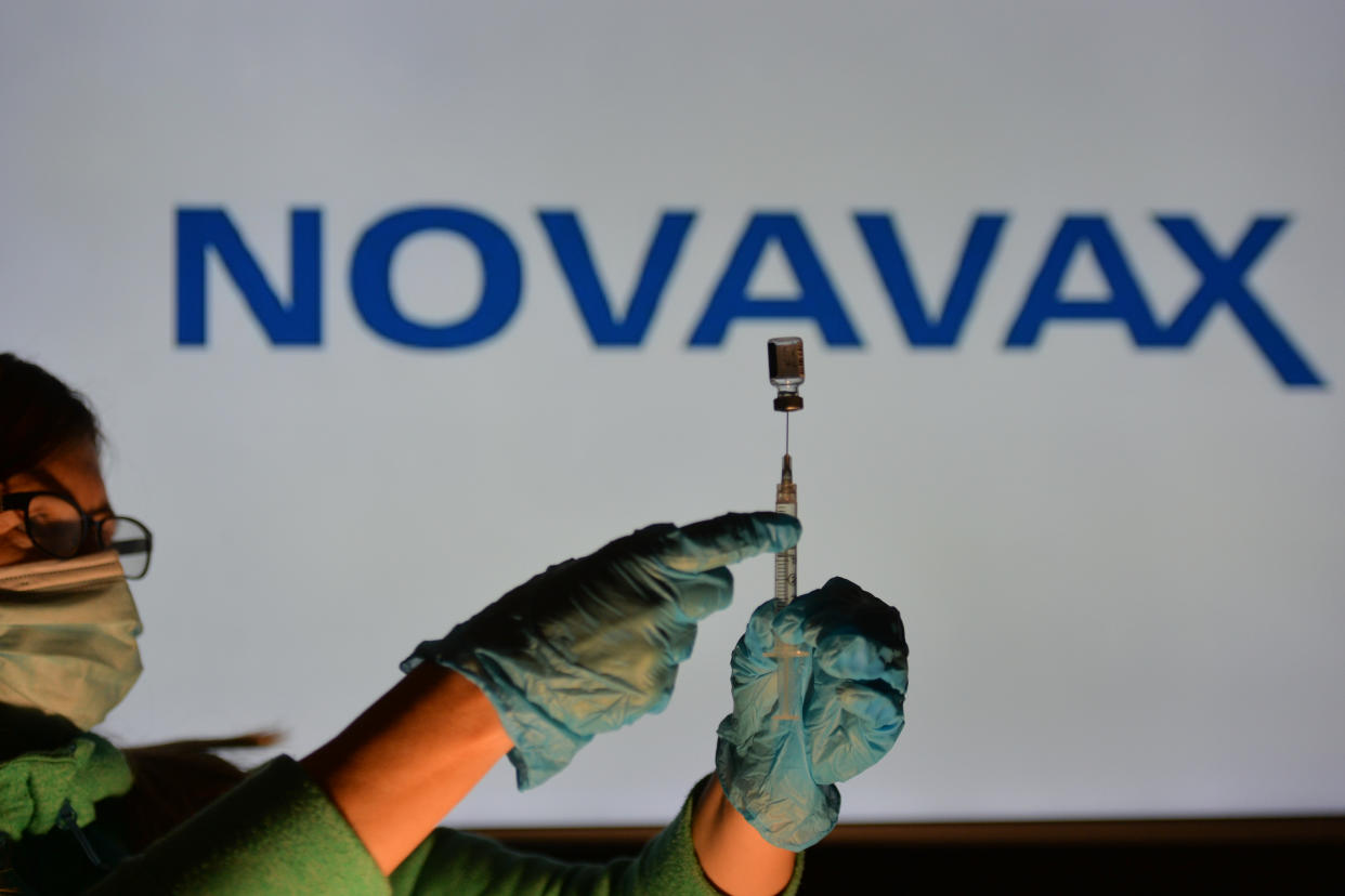 An illustrative image of a person holding a medical syringe and a vaccine vial in front of the Novavax logo displayed on a screen.
On Thursday, October 21, 2021, in Edmonton, Alberta, Canada. (Photo by Artur Widak/NurPhoto via Getty Images)