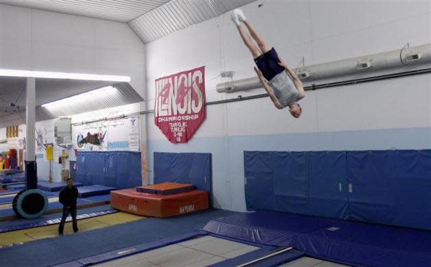 U.S. trampoline gymnast Michael Devine trains for the London 2012 Olympics at his home gym, the J and J Tumbling and Trampoline Team Center, while his coach Shaun Kempton (L) looks on in Pecatonica, Illinois, May 7, 2012.