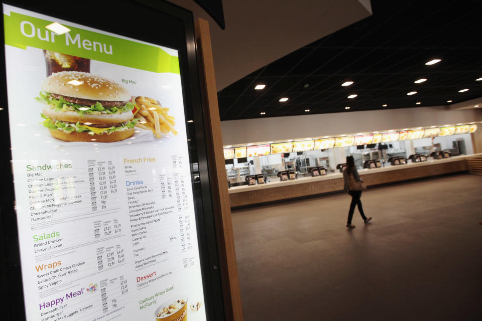 LONDON, ENGLAND - JUNE 25: A woman walks past the checkouts in the world's largest McDonald's restaurant which is their flagship outlet in the Olympic Park on June 25, 2012 in London, England. The restaurant, which is one of four McDonald's to be situated within the Olympic Park, will have a staff of 500. After the Olympic and Paralympic Games conclude the restaurant will be dismantled and all fixtures and fittings will be either reused or recycled. (Photo by Oli Scarff/Getty Images)