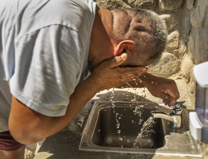 VAN NUYS, CA -SEPTEMBER 7, 2022: Hector Montero, 55, cools off after washing his ice cream truck at Lake Balboa Park in Van Nuys. A heat wave that has shattered temperature records nearly broke California's overtaxed electric grid, pushing it to the brink of rolling blackouts but narrowly averting widespread power loss. (Mel Melcon / Los Angeles Times)