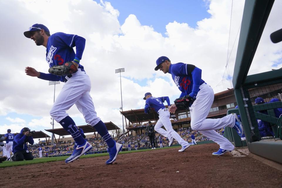 Dodgers left fielder Chris Taylor, first baseman Freddie Freeman and center fielder Trayce Thompson take the field.