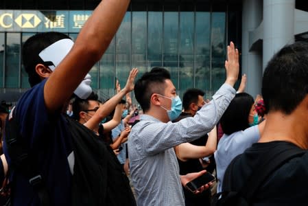 Anti-government office workers wearing masks attend a lunch time protest, after local media reported on an expected ban on face masks under emergency law, at Central, in Hong Kong