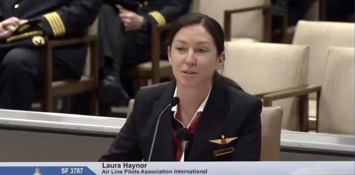 Haynor, in a pilot uniform, speaking at a podium with a nameplate that reads, "Laura Haynor, Air Line Pilots Association International"