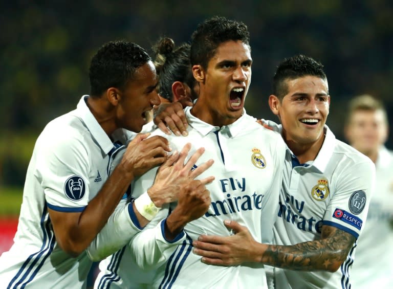 Real Madrid's French defender Raphael Varane (C) celebrates with teammates after scoring a goal during their UEFA Champions League Group F match against Borussia Dortmund, at BVB stadium in Dortmund, on September 27, 2016