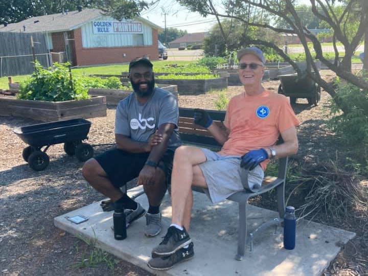 Two smiling men sitting on a bench