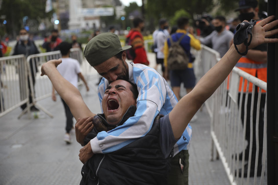 FILE - In this Nov. 26, 2020, file photo, mourners react as they wait to see Diego Maradona lying in state outside the presidential palace in Buenos Aires, Argentina. The Argentine soccer great who led his country to the 1986 World Cup died Wednesday at the age of 60. (AP Photo/Rodrigo Abd, File)