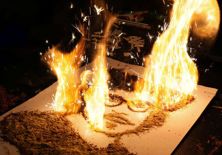 A portrait of actor Johnny Depp made of tobacco, by artist Abdelrahman al-Habrouk, burns in Alexanria, Egypt August 10, 2017. REUTERS/Mohamed Abd El Ghany