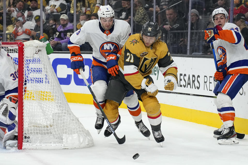 New York Islanders defenseman Adam Pelech (3) and Vegas Golden Knights William Karlsson battle for the puck during the second period of an NHL hockey game, Sunday, Oct. 24, 2021, in Las Vegas. (AP Photo/Rick Scuteri)