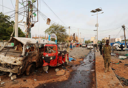 A Somali security officer walks past destroyed vehicles at the scene of an explosion in Mogadishu, Somalia November 9, 2018. REUTERS/Feisal Omar