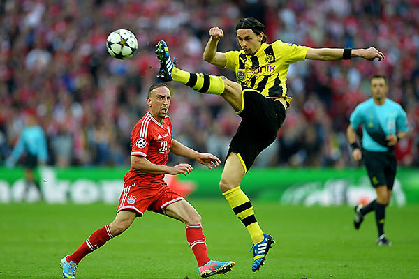 Franck Ribery of Bayern Muenchen (L) in action with Neven Subotic of Borussia Dortmund.