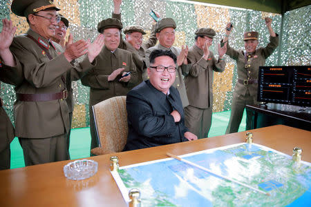 FILE PHOTO : Kim Jong Un reacts with Ri Pyong Chol (C in rear line) and Jang Chang Ha (R) during a test launch of ground-to-ground medium long-range ballistic rocket Hwasong-10 in this undated photo released June 23, 2016. REUTERS/KCNA/File Photo