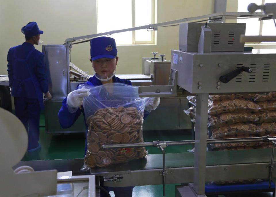 In this Oct. 22, 2018, photo, a worker monitors the production of bottled beverage at Songdowon General Foodstuffs Factory in Wonsan, North Korea. The factory produces cookies, crackers, candies and bakery goods, plus dozens of varieties of soft drinks, that are sold all across the country. (AP Photo/Dita Alangkara)
