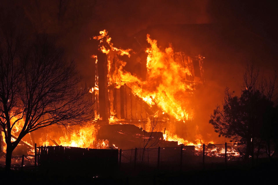 FILE - Homes burn as a wildfire rips through a development near Rock Creek Village, Dec. 30, 2021, near Broomfield, Colo. Authorities say they have wrapped up their investigation into what started the most destructive wildfire in Colorado history and will announce their findings on Thursday, June 8, 2023. (AP Photo/David Zalubowski, File)