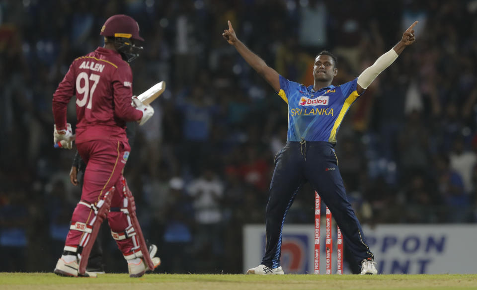 Sri Lanka's Angelo Mathews celebrates the dismissal of West Indies' Fabian Allen, left, during their third one day international cricket match in Pallekele, Sri Lanka, Sunday, March 1, 2020. (AP Photo/Eranga Jayawardena)