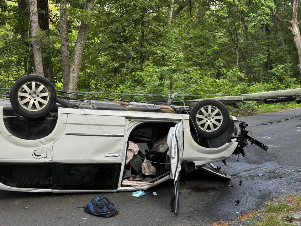 In this photo provided by Woodstock Volunteer Fire Association, a minivan carrying more than a dozen puppies hit a utility pole and rolled over in Woodstock, Conn., Thursday morning, June 20, 2024, injuring several dogs, authorities said. The driver was not seriously hurt, but several dogs were brought to a veterinarian center in nearby Massachusetts to be examined. (Josh Bottone/Woodstock Volunteer Fire Association via AP)