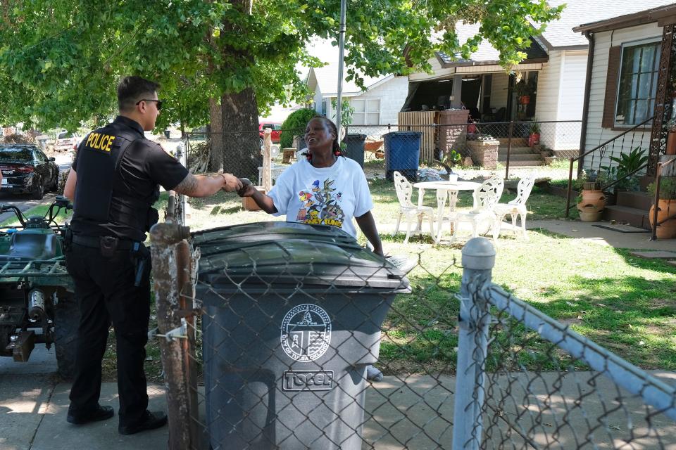 Muscogee Nation Lighthorse Police Officer Daryl Wilson hands out police stickers to a woman whose family watched an arrest unfold in front of their house.