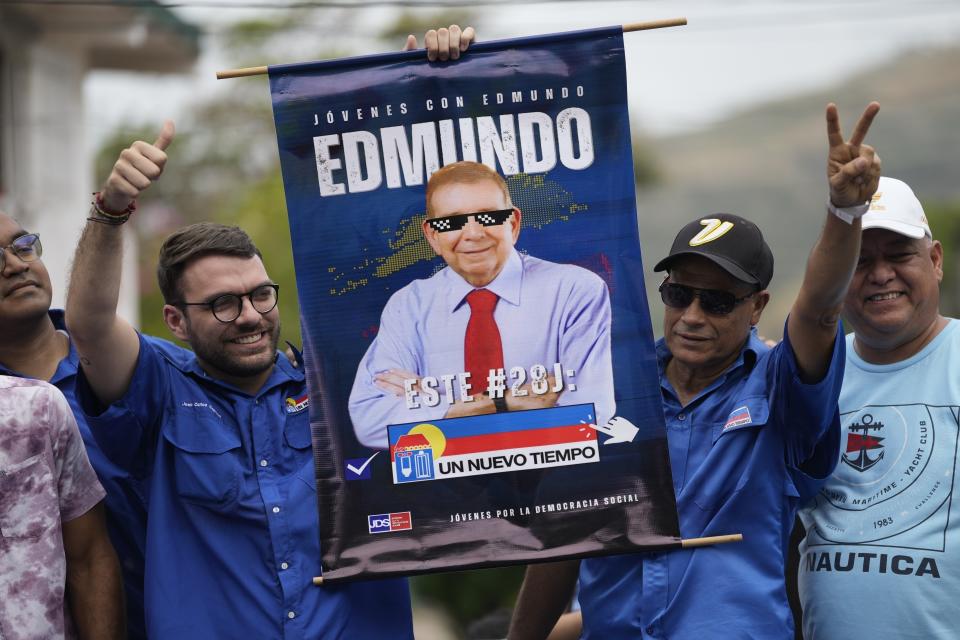 ARCHIVO - Seguidores del candidato presidencial de la oposición venezolana Edmundo González con un cartel de apoyo en el lanzamiento de la campaña política para las elecciones próximas en La Victoria, Venezuela, el 18 de mayo de 2024. (AP Foto/Ariana Cubillos, Archivo)