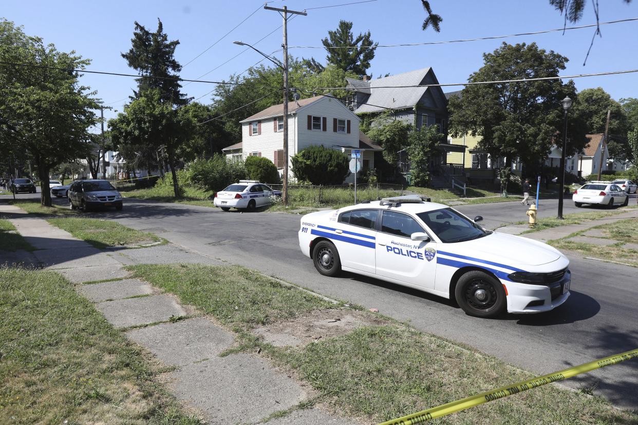 Rochester police collect evidence in the area of Bauman and Laser Streets where two officers were shot last night, in Rochester, N.Y., on Friday.