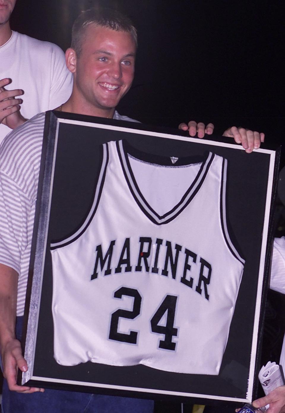 Teddy Dupay holds his former Mariner High School basketball jersey that was retired.