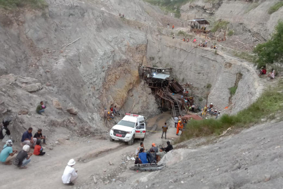 Rescuers and workers wait at the entrance of a coal mine during the search for victims after an explosion Friday, Dec. 9, 2022, in Sawahlunto, West Sumatra, Indonesia. A number of people died in the explosion. (AP Photo/Devanya Zianisa)