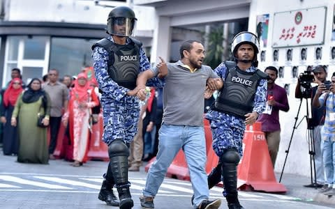 Maldivian police arrest a man during protests in March 2018 - Credit: Getty