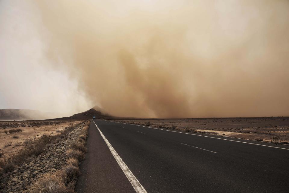 In this July 12, 2019 photo, a sandstorm gusts over a road where African migrants walk, around 50 kilometers (31 miles) from Djibouti. The number of girls among the migrants has had an enormous increase, quadrupling from 2,075 to 8,360 in one year. Despite the many risks of smugglers' exploitation, rape, hunger, drowning – they are undaunted. (AP Photo/Nariman El-Mofty)