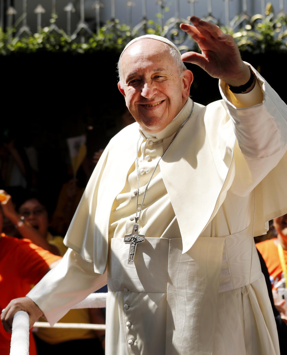 Pope Francis waves to a crowd standing hours to greet him as he arrives at the St. Louis Hospital in Bangkok, Thailand, Thursday, Nov. 21, 2019. Pope Francis called for migrants to be welcomed and for women and children to be protected from exploitation, abuse and enslavement as he began a busy two days of activities in Thailand on Thursday. (AP Photo/Manish Swarup)