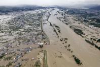 Residential area, left, are submerged in muddy waters after an embankment of the Chikuma River broke because of Typhoon Hagibis, in Nagano, central Japan, Sunday, Oct. 13, 2019. Rescue efforts for people stranded in flooded areas are in full force after a powerful typhoon dashed heavy rainfall and winds through a widespread area of Japan, including Tokyo.(Yohei Kanasashi/Kyodo News via AP)