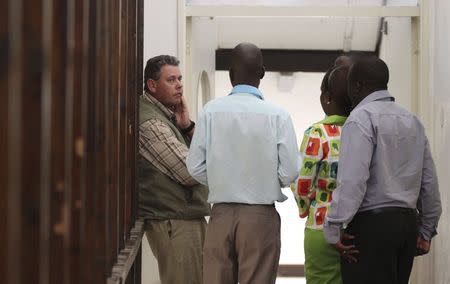 Zimbabwean hunter Theo Bronkhorst is escorted by police as he waits to appear in Hwange magistrates court, July 29, 2015. REUTERS/Philimon Bulawayo
