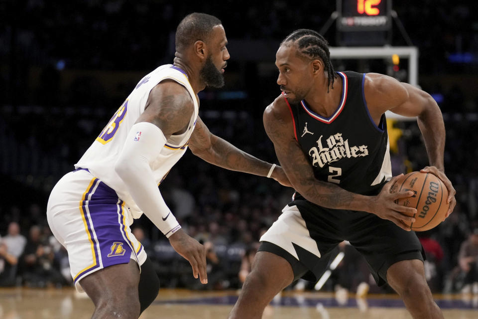 Los Angeles Lakers forward LeBron James, left, covers Los Angeles Clippers forward Kawhi Leonard (2) during the second half of an NBA basketball game in Los Angeles, Sunday, Jan. 7, 2024. (AP Photo/Eric Thayer)