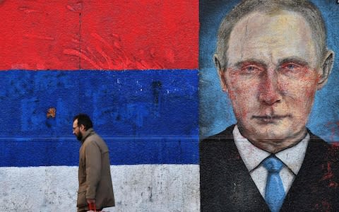 A man walks past a mural depicting Russian President Vladimir Putin on January 14, 2019, in Belgrade - Credit: ANDREJ ISAKOVIC/AFP/Getty Images