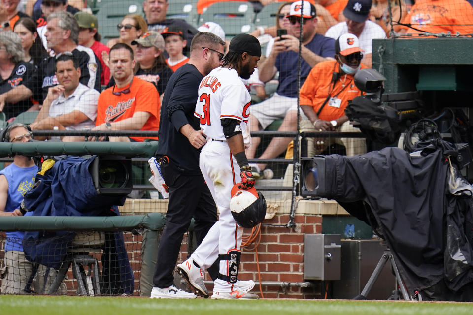 Baltimore Orioles' Cedric Mullins walks off the field with a member of the training staff during the eighth inning of a baseball game against the Cleveland Guardians, Monday, May 29, 2023, in Baltimore. The Guardians won 5-0. (AP Photo/Julio Cortez)