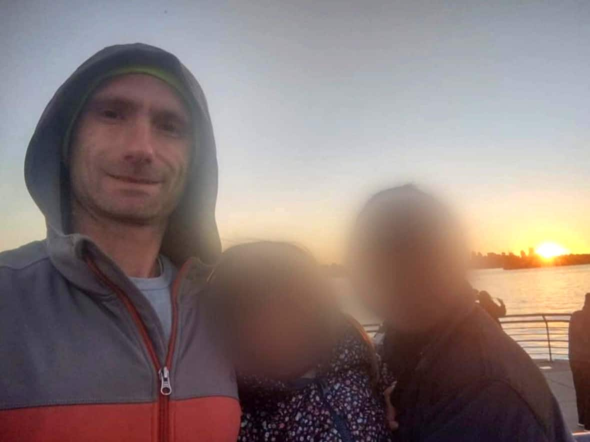 Paul Schmidt, left, poses for a photo with his fiancée and three-and-a-half-year-old daughter, whose faces have been blurred for privacy reasons. Police have identified Schmidt, 37, as the man who was fatally stabbed outside a Starbucks Sunday evening.  (Kathy Schmidt - image credit)