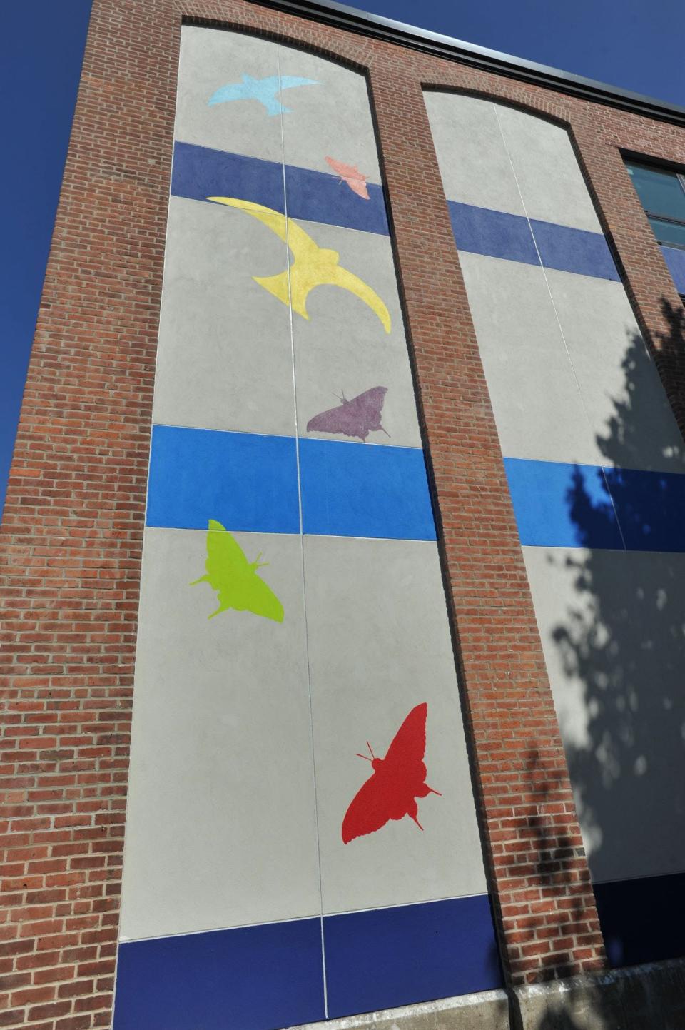 Colorful birds and butterflies grace the front of the new Dr. Rick DeCristofaro Learning Center in Quincy.