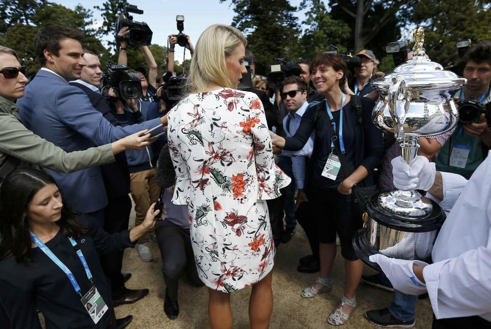 Germany's Angelique Kerber is surrounded by the media as she looks at the women's singles trophy, a day after winning her final match at the Australian Open tennis tournament, at the Government House in Melbourne, Australia, January 31, 2016. REUTERS/Issei Kato