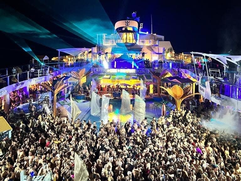 a packed cruise deck filled with people at night